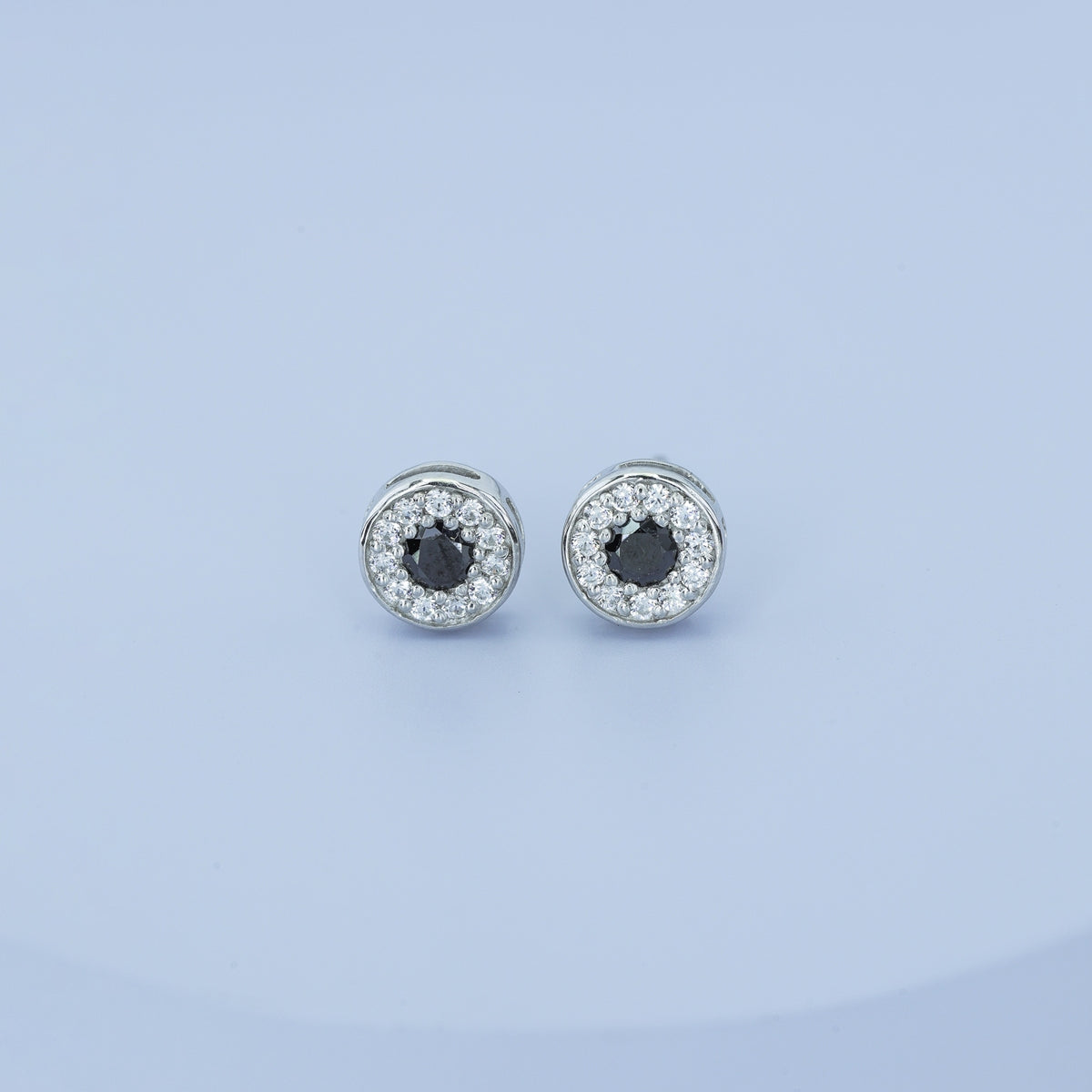 Black halo round cluster stud earrings with white pave surround and circular bezel frame