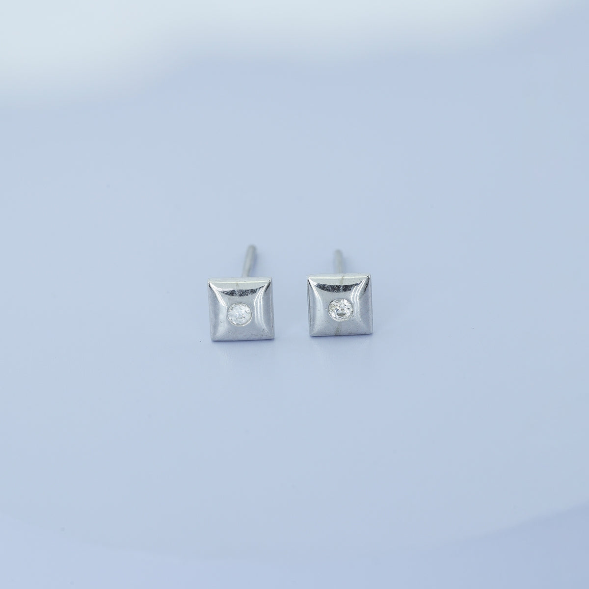 Chaukor stud earrings with diamond-shaped geometric frame and bezel-set round centre stone