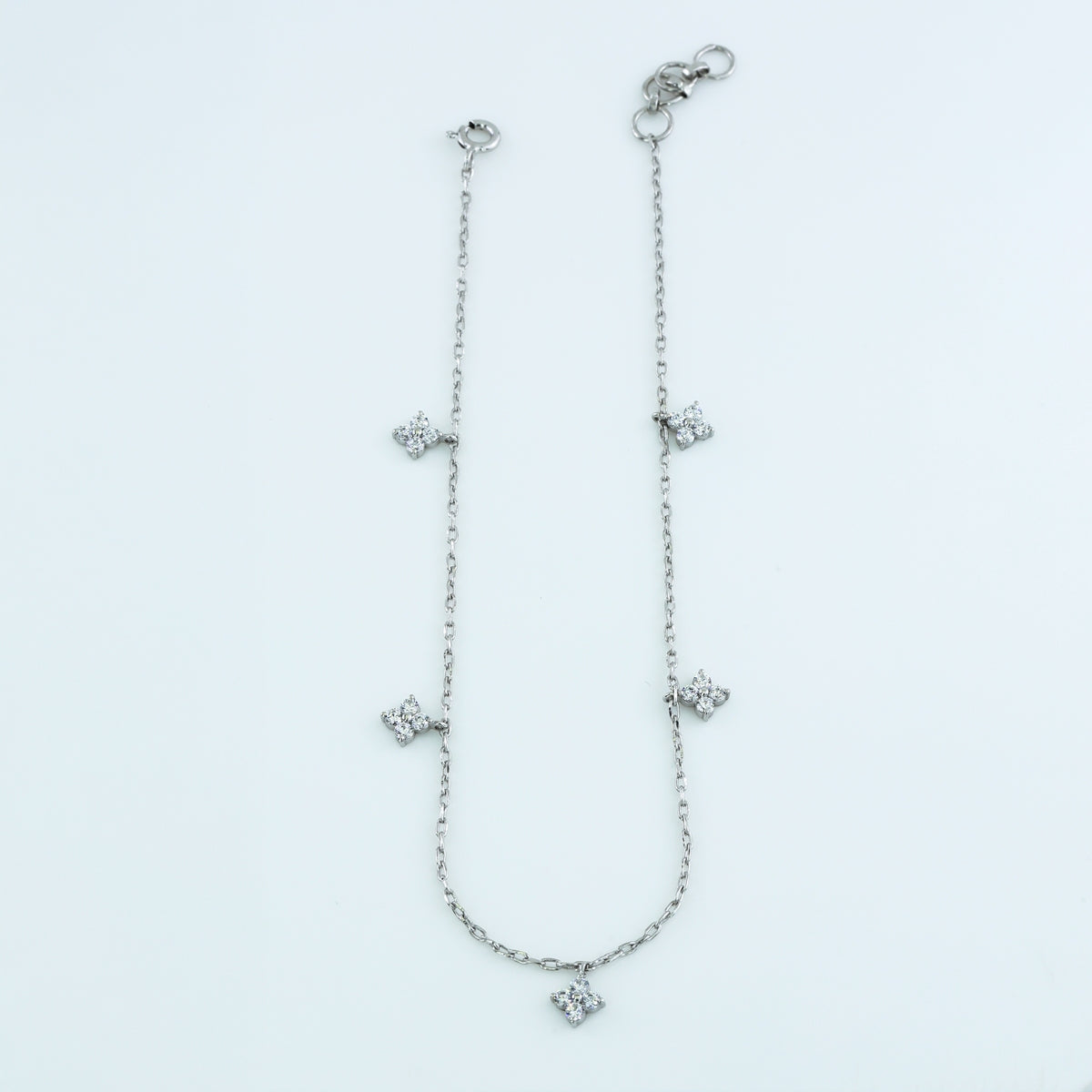 Diamond star charm anklet with delicate chain and five dangling four point star shaped stone charms
