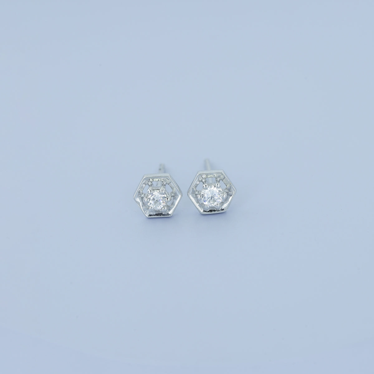 Hexagon stud earrings with geometric frame and raised round centre