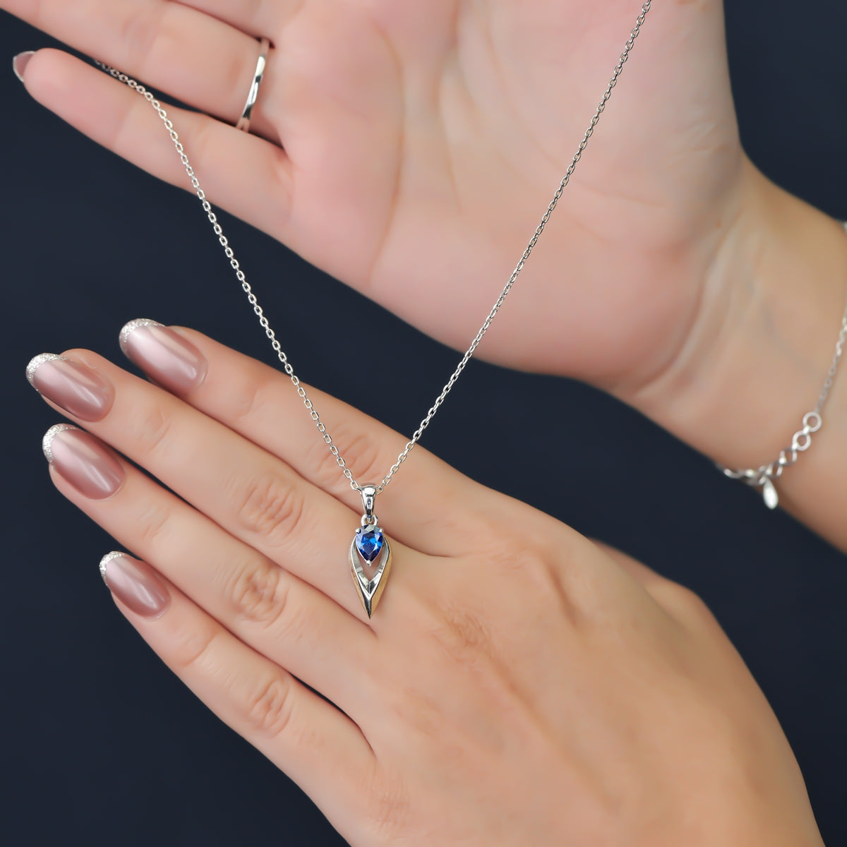 Silver chain necklace with a pointed frame blue gem pendant