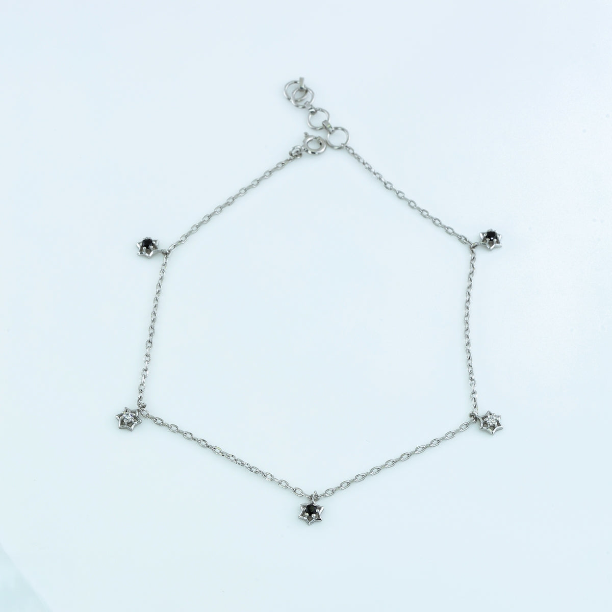 Black and white stone charm anklet with delicate chain and alternating filled and open shaped charms