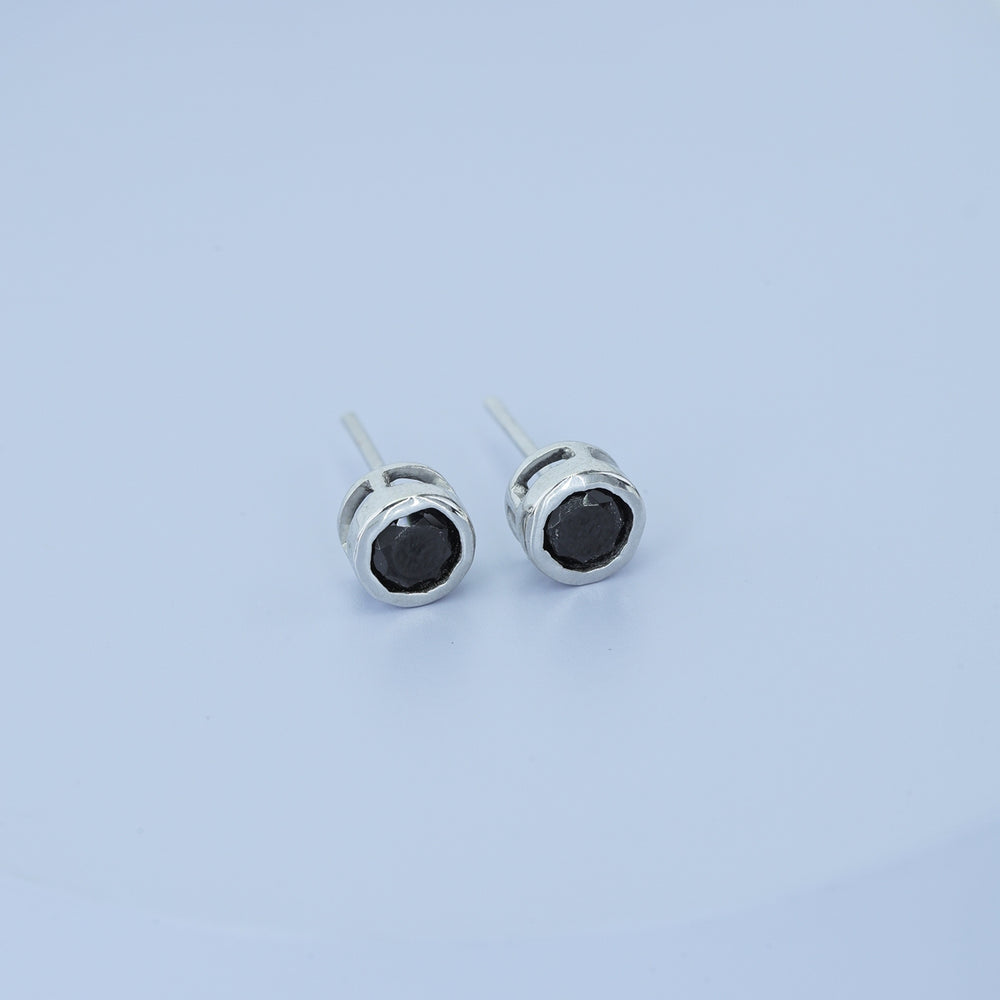 Black round stud earrings with polished circular bezel frame