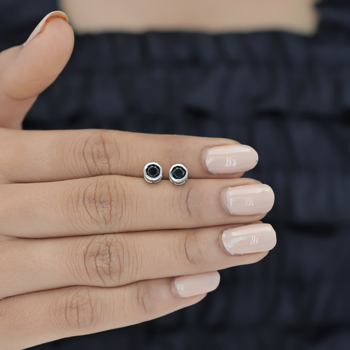 Black round stud earrings with polished circular bezel frame