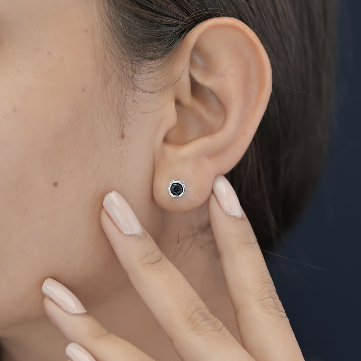 Black round stud earrings with polished circular bezel frame