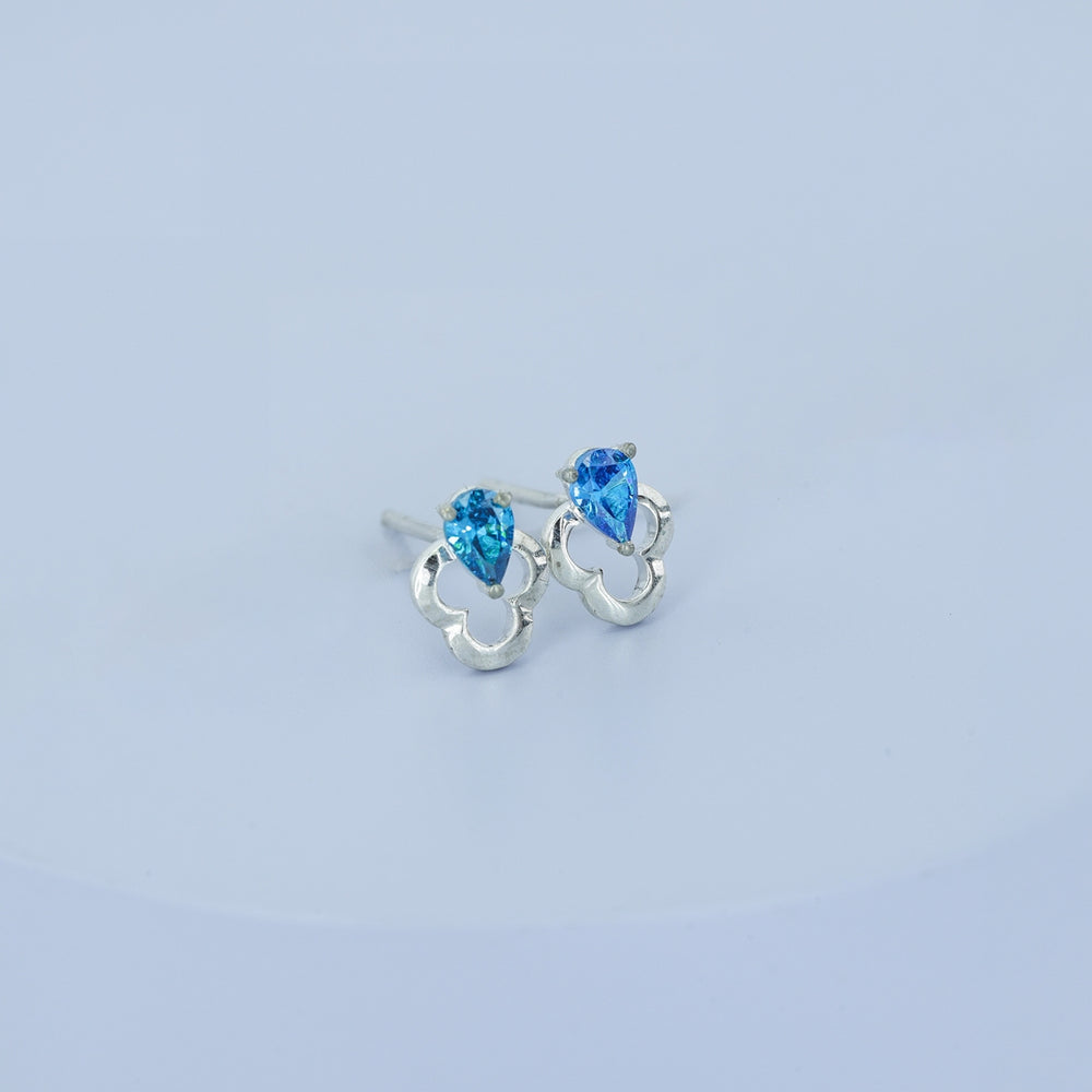 Blue pear drop floral stud earrings with open quatrefoil base and raised stone top