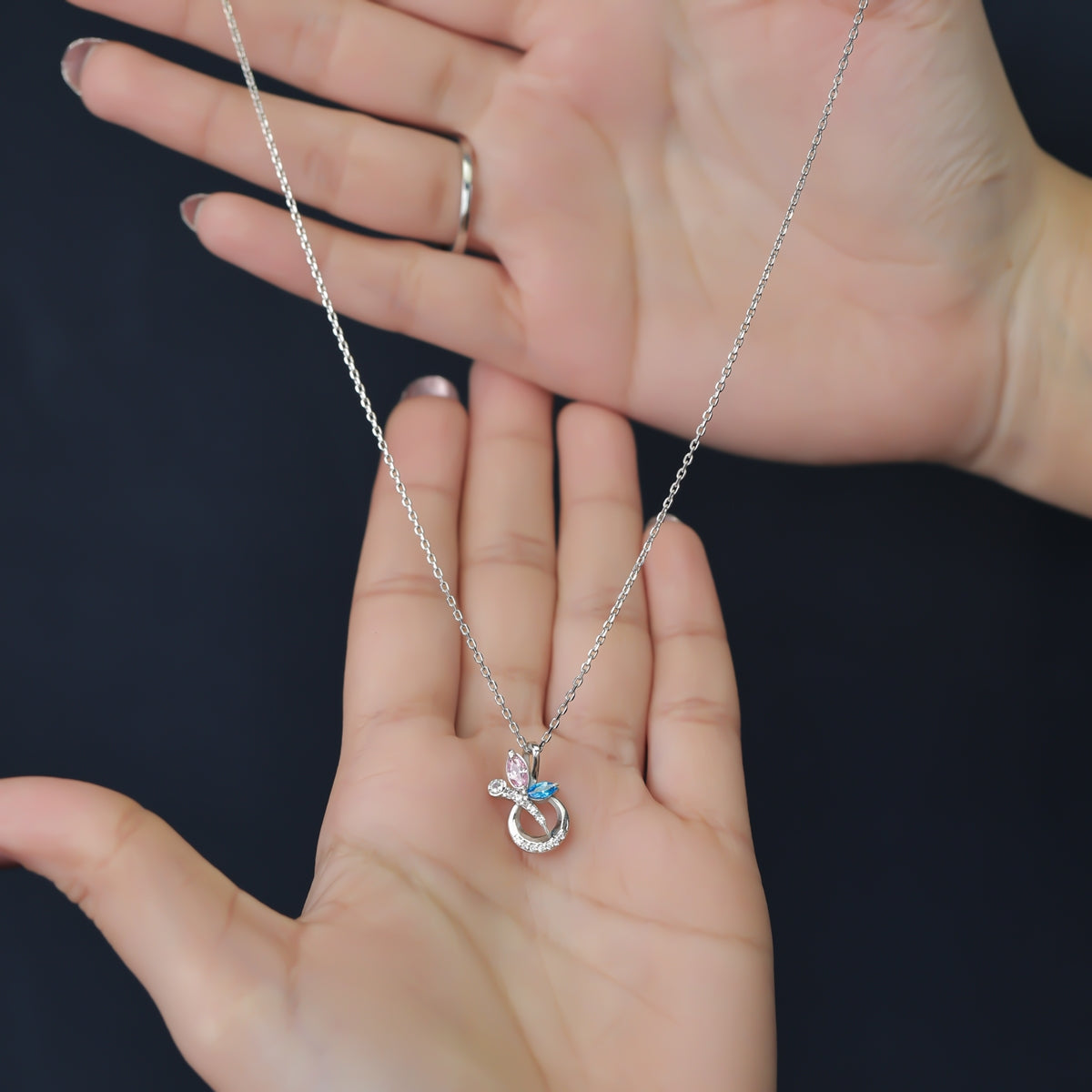 Silver chain necklace with a crescent pendant set with pink and blue stones