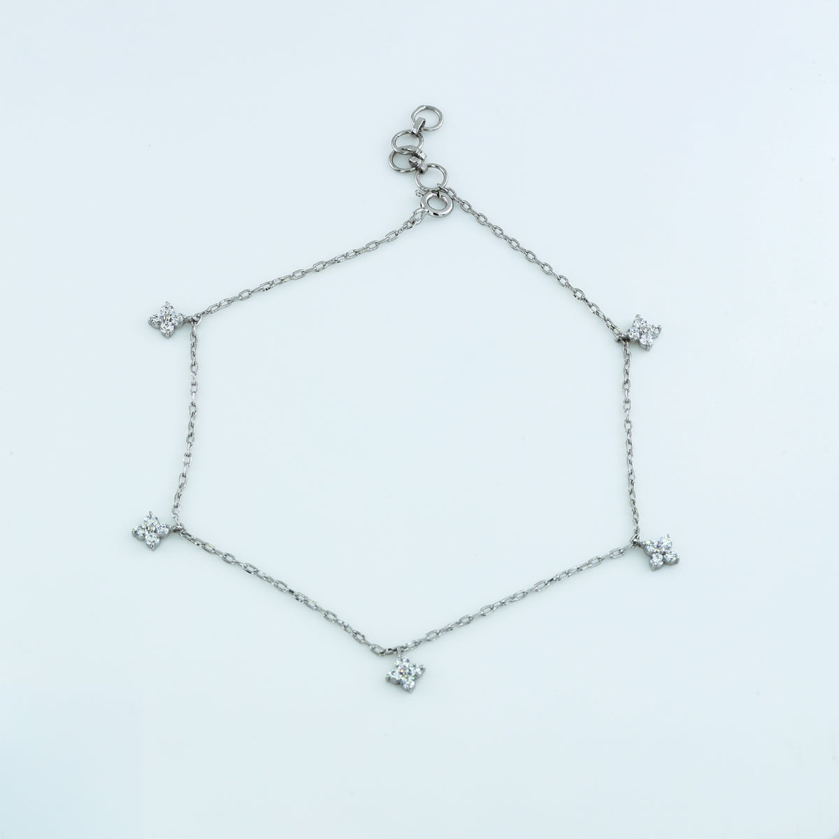 Diamond star charm anklet with delicate chain and five dangling four point star shaped stone charms