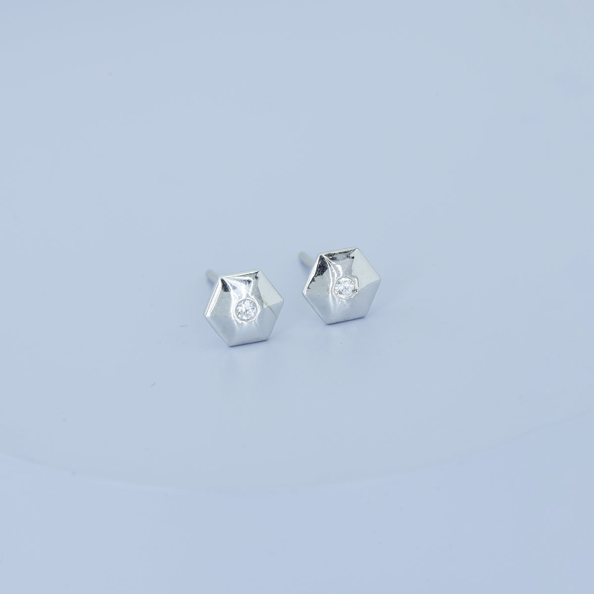 Geometric cube solitaire stud earrings with hexagonal frame and round centre stone
