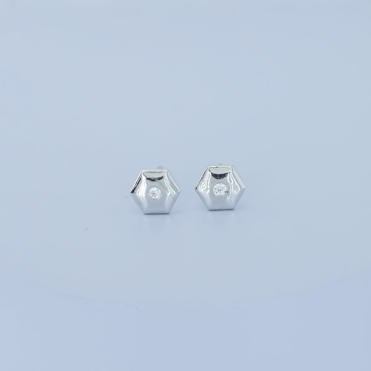 Geometric cube solitaire stud earrings with hexagonal frame and round centre stone