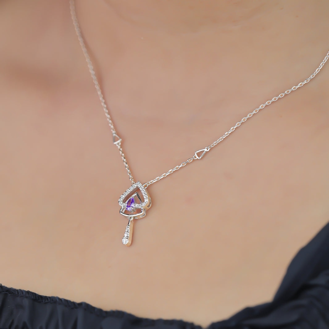 Silver chain necklace with a layered triangular pendant and purple gem