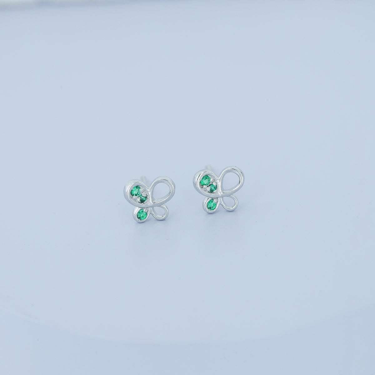 Green butterfly stud earrings with open loop wings and round green stone accents