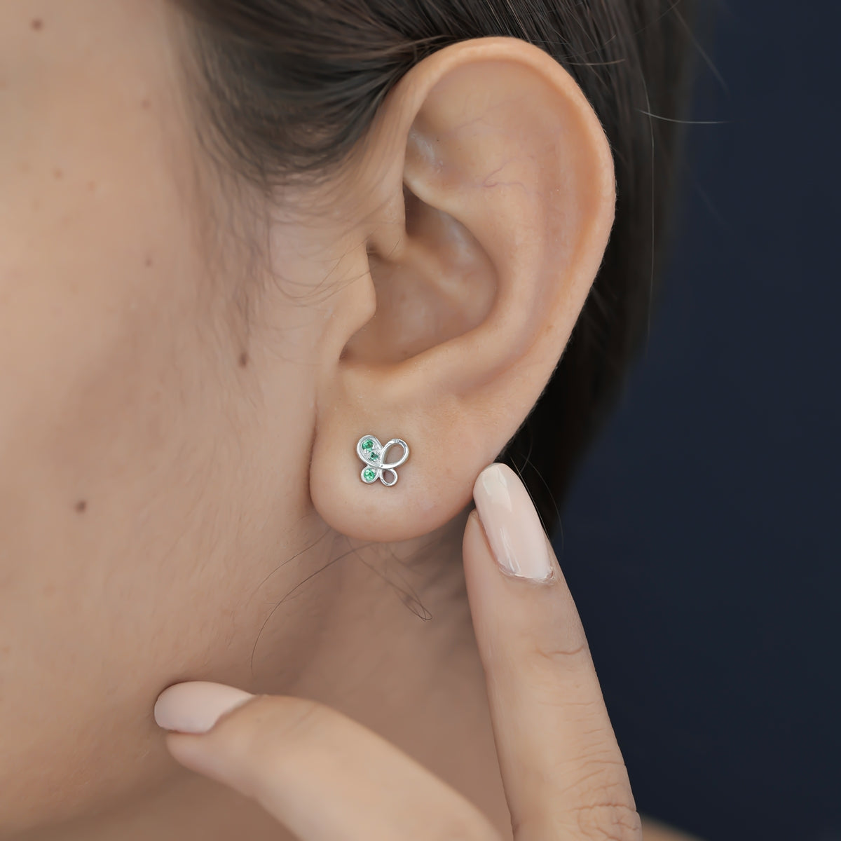 Green butterfly stud earrings with open loop wings and round green stone accents