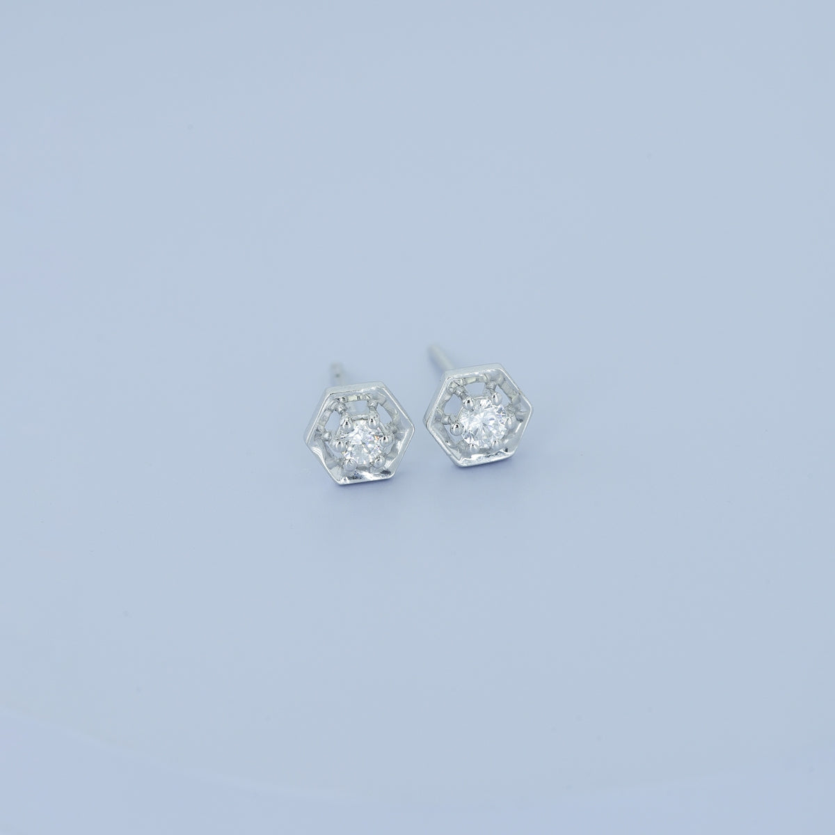 Hexagon stud earrings with geometric frame and raised round centre