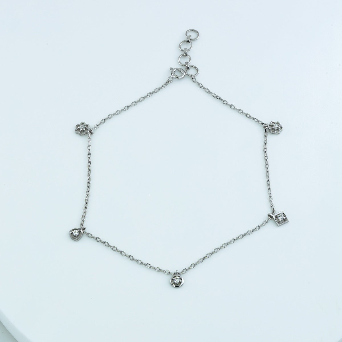 Mixed shape charm anklet with delicate chain and five varied geometric round stone station charms