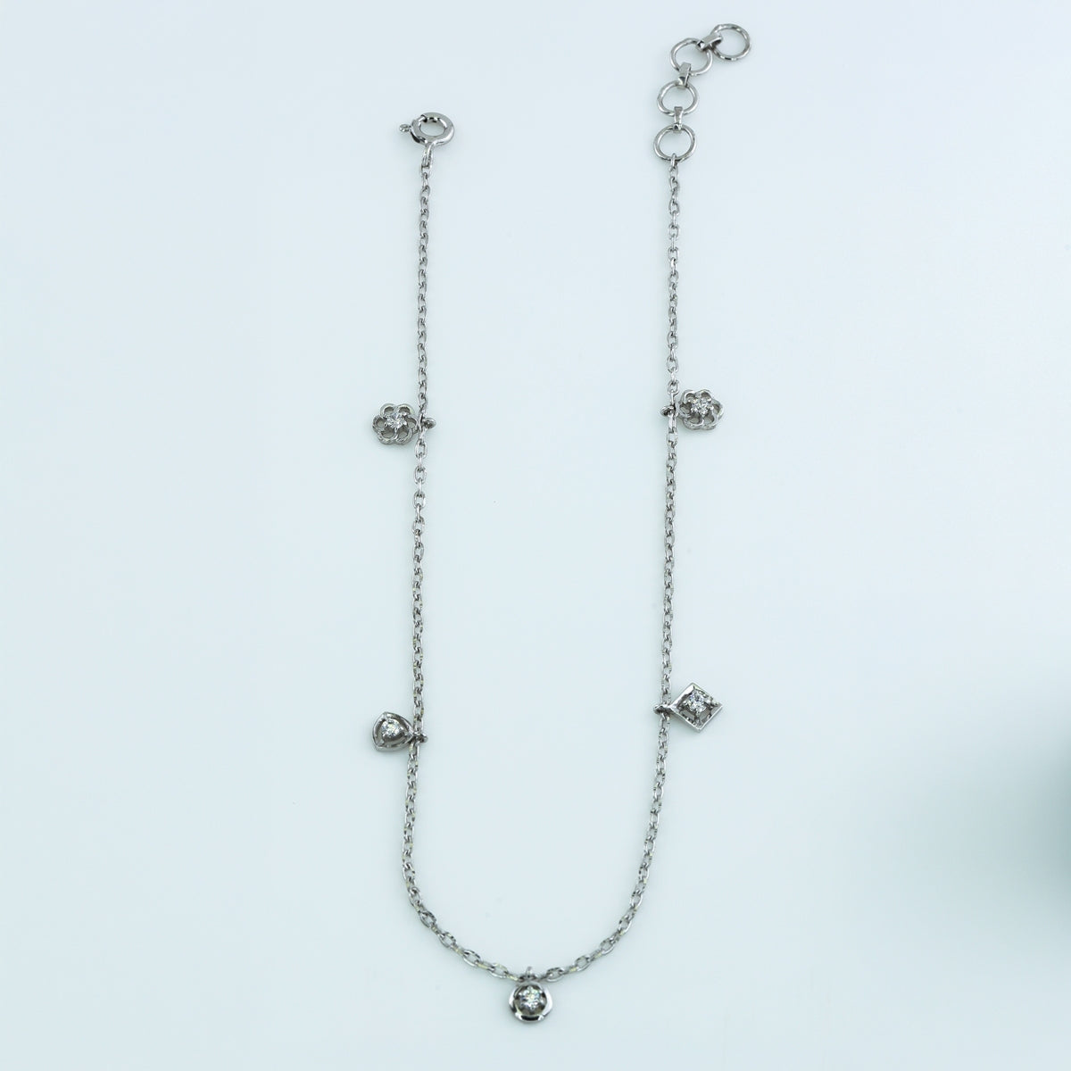 Mixed shape charm anklet with delicate chain and five varied geometric round stone station charms