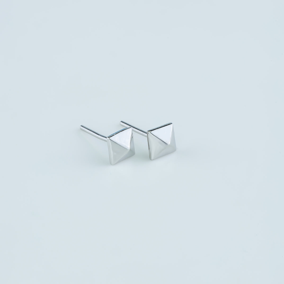 Modern pyramid stud earrings with smooth square base and raised geometric peak