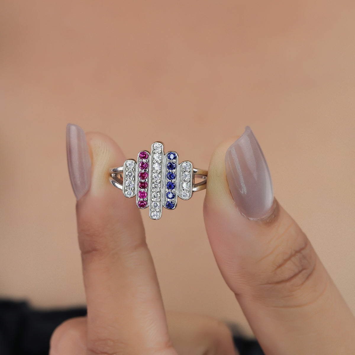 Statement ring featuring vertical rows of clear, pink, and dark blue stones