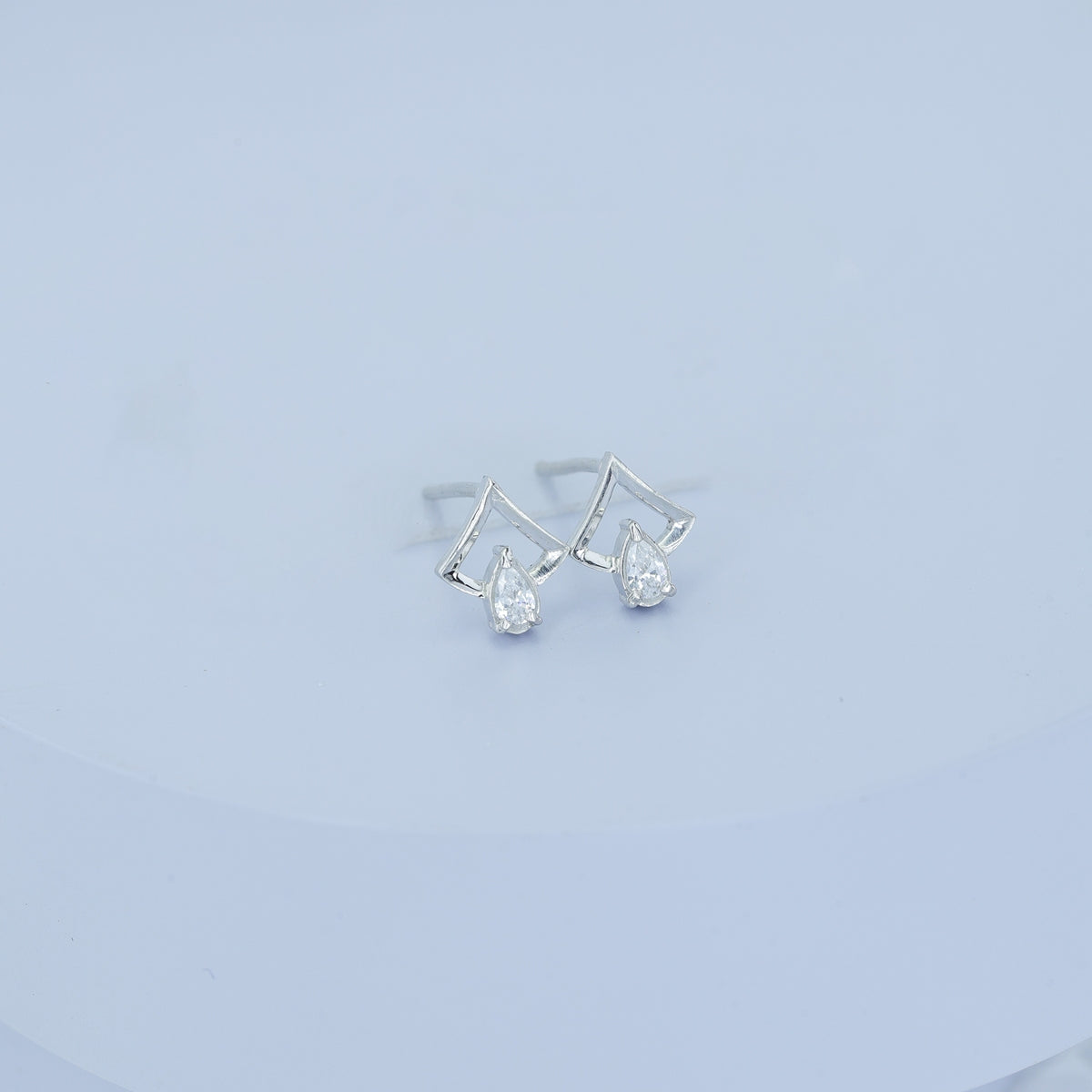 Pear drop chevron frame stud earrings with open angular top and raised stone base