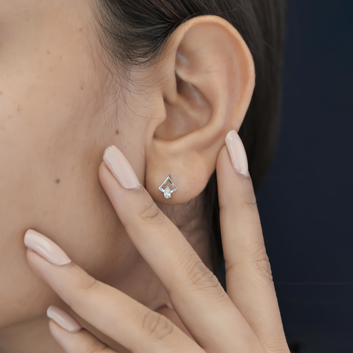 Pear drop chevron frame stud earrings with open angular top and raised stone base