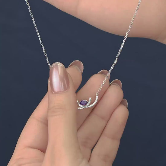 Crescent pendant necklace with a purple stone and delicate silver detailing