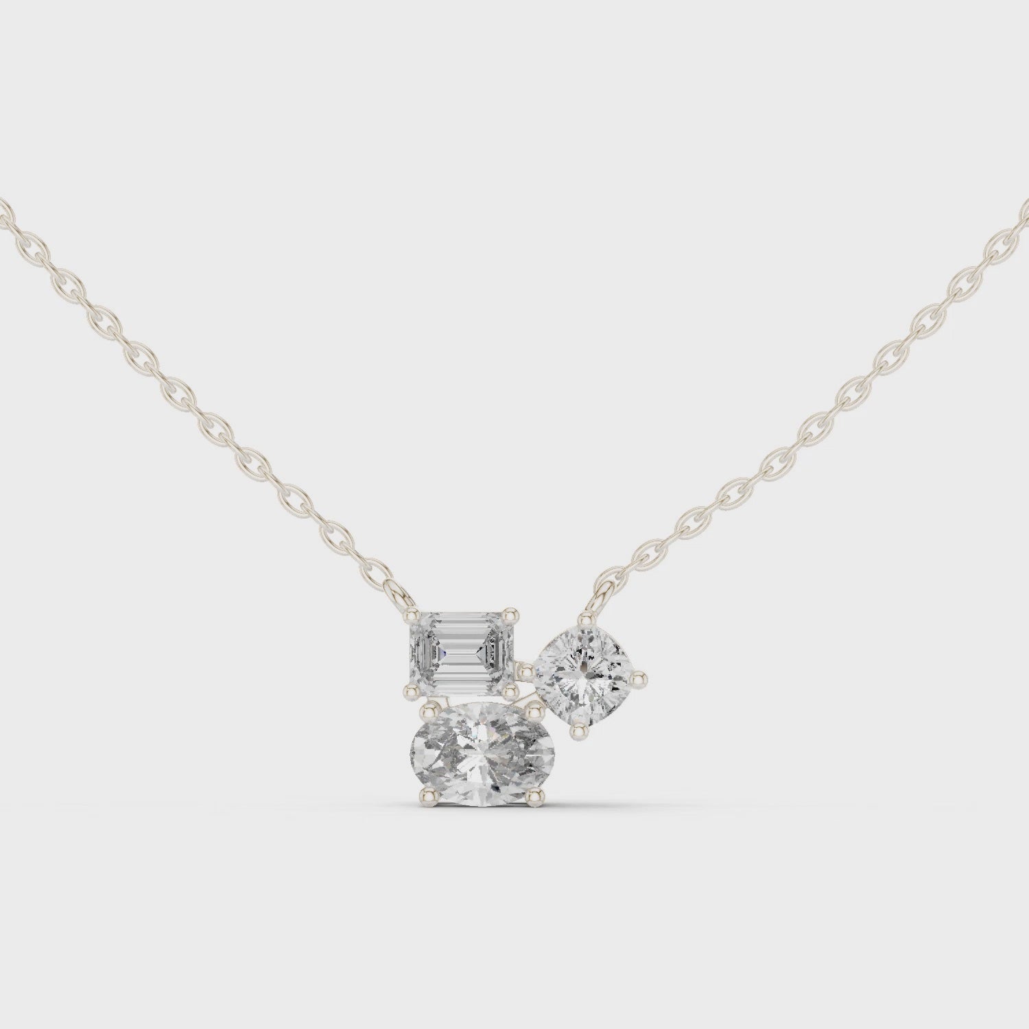Multi shape cluster diamond pendant necklace with emerald, round and cushion cut stones