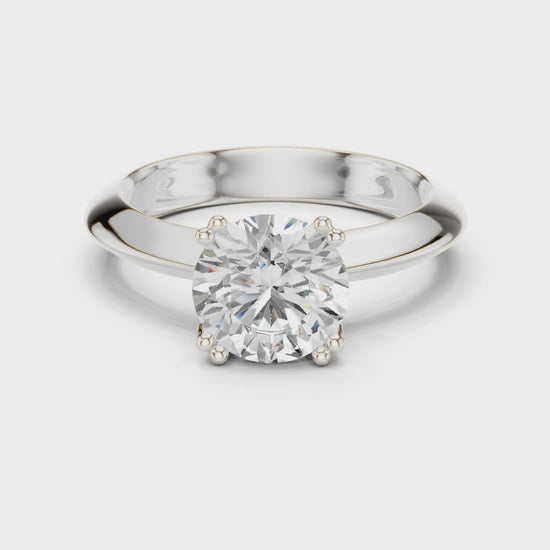 Classic round solitaire engagement ring with six prong cathedral setting and plain tapered band