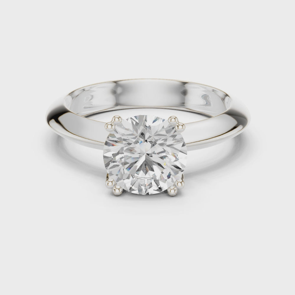 Classic round solitaire engagement ring with six prong cathedral setting and plain tapered band