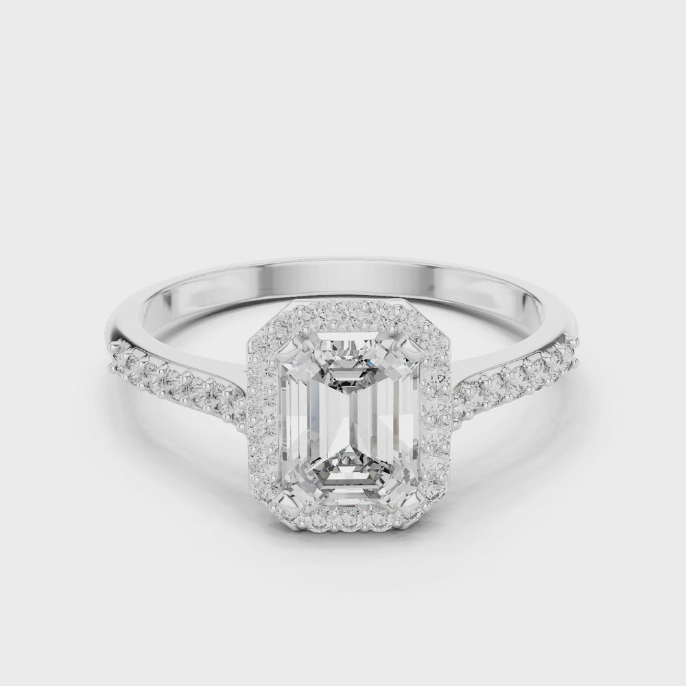 Emerald cut halo engagement ring with pave set shoulders and tapered split band