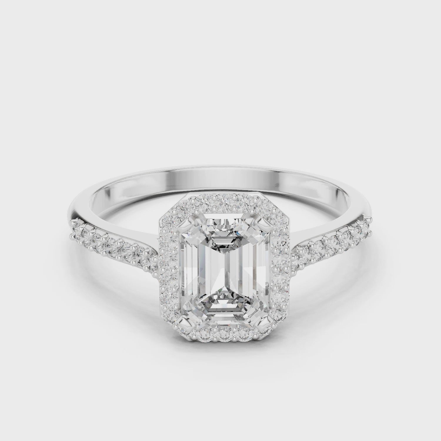 Emerald cut halo engagement ring with pave set shoulders and tapered split band