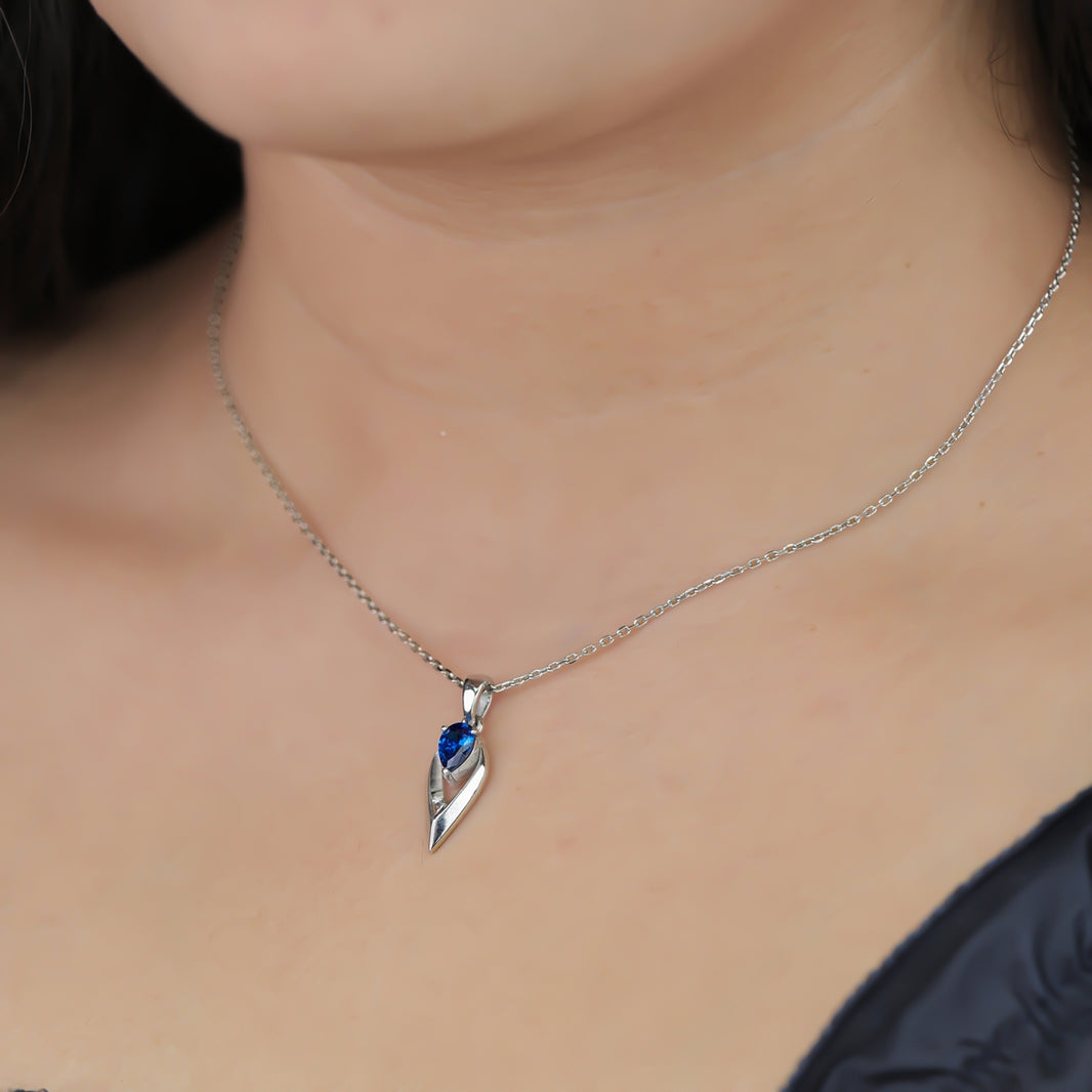 Silver chain necklace with a pointed frame blue gem pendant