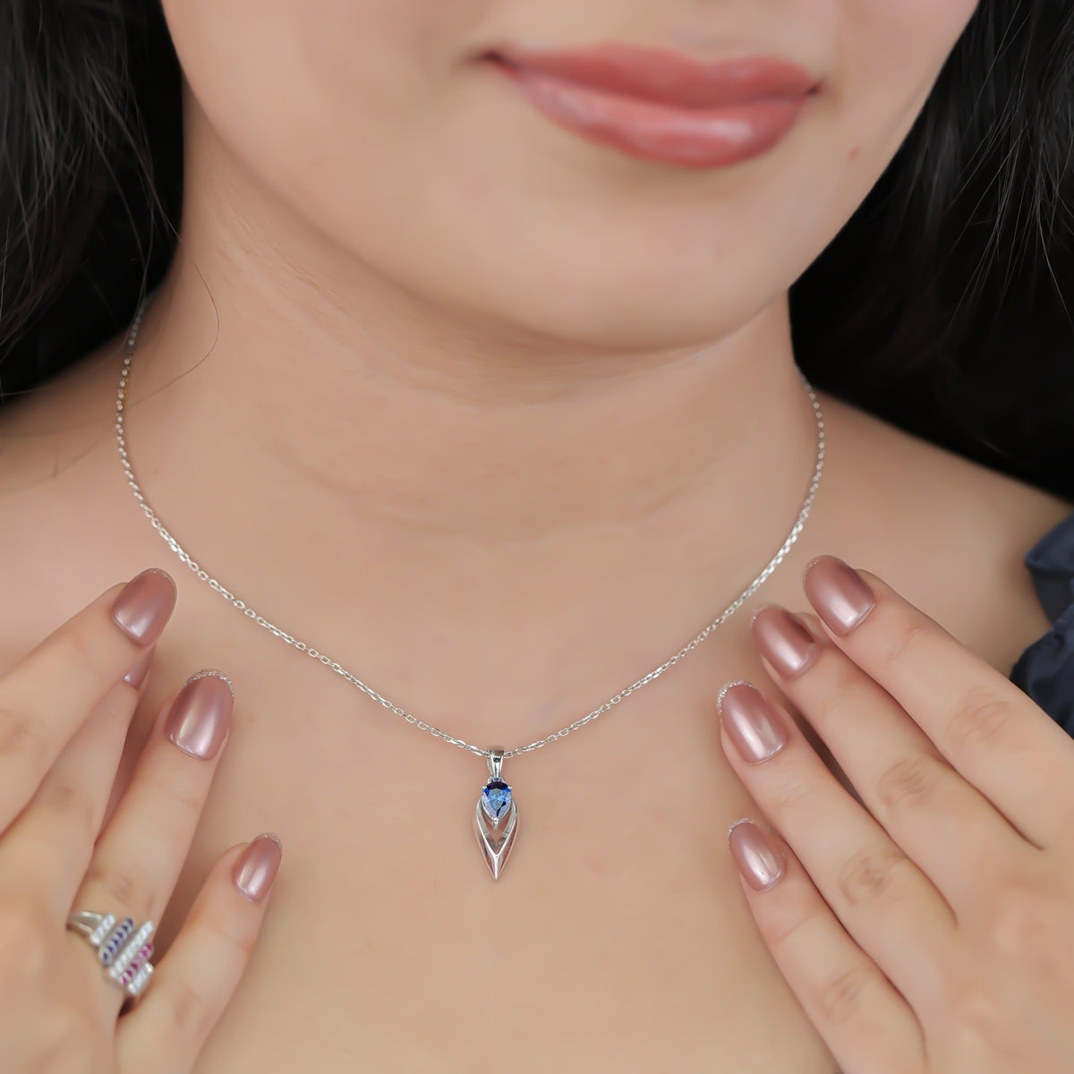 Silver chain necklace with a pointed frame blue gem pendant