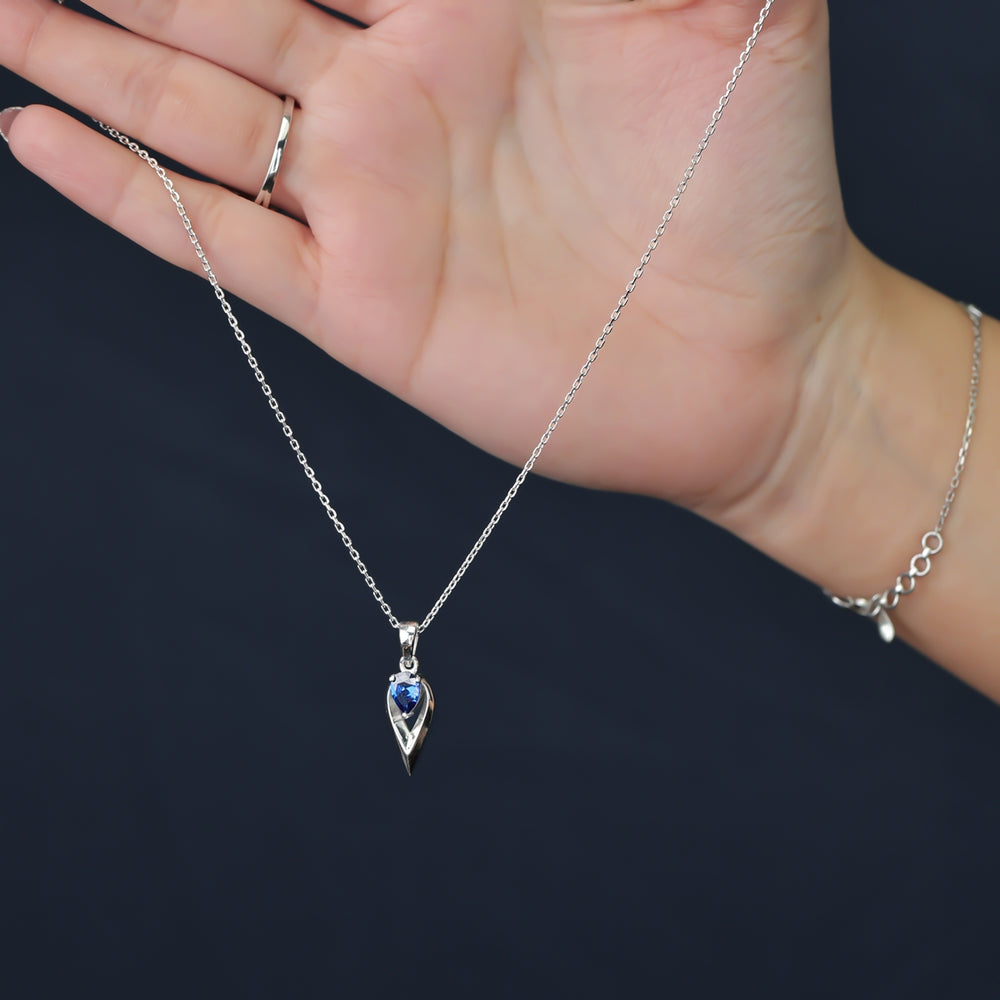 Silver chain necklace with a pointed frame blue gem pendant
