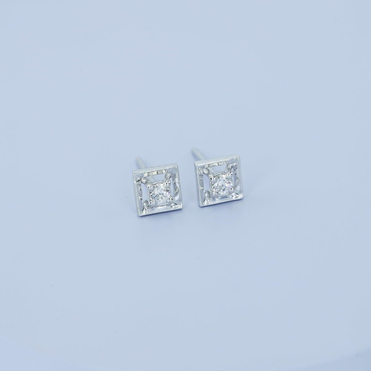 Square claw stud earrings with tilted open frame and raised round centre