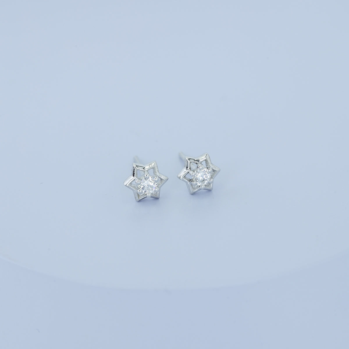 Star burst stud earrings with pointed geometric frame and raised centre