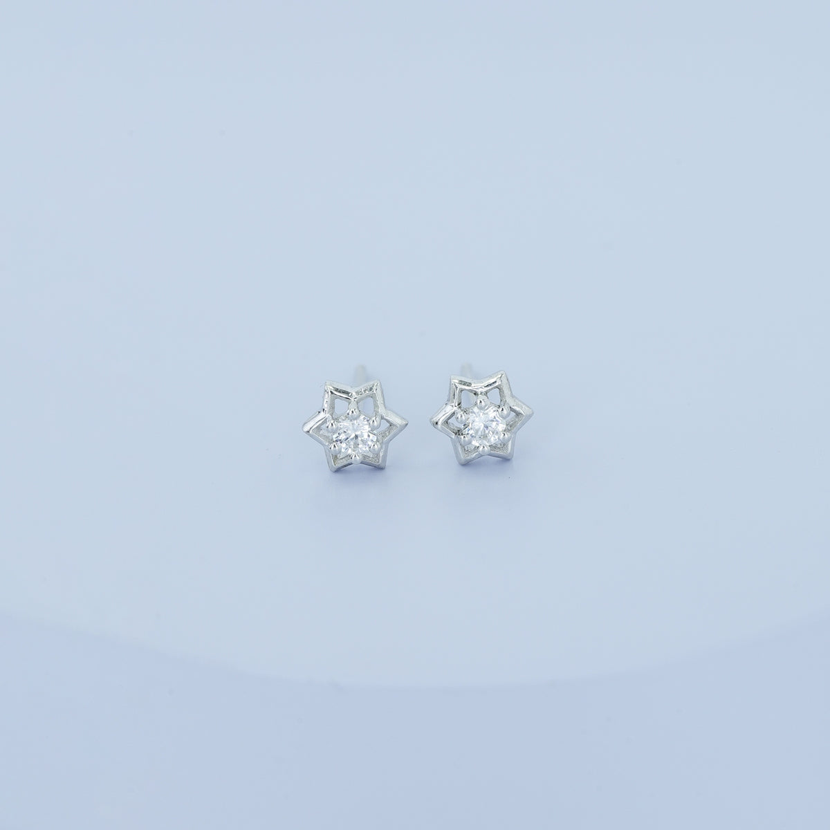 Star burst stud earrings with pointed geometric frame and raised centre