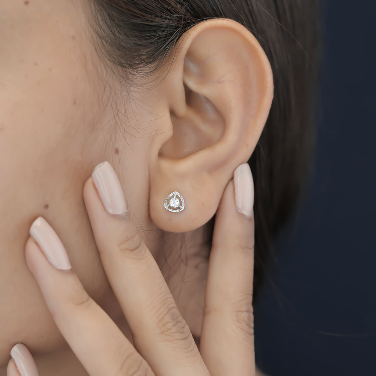 Triangle halo diamond stud earrings with open triangular frame and prong-set round centre stone
