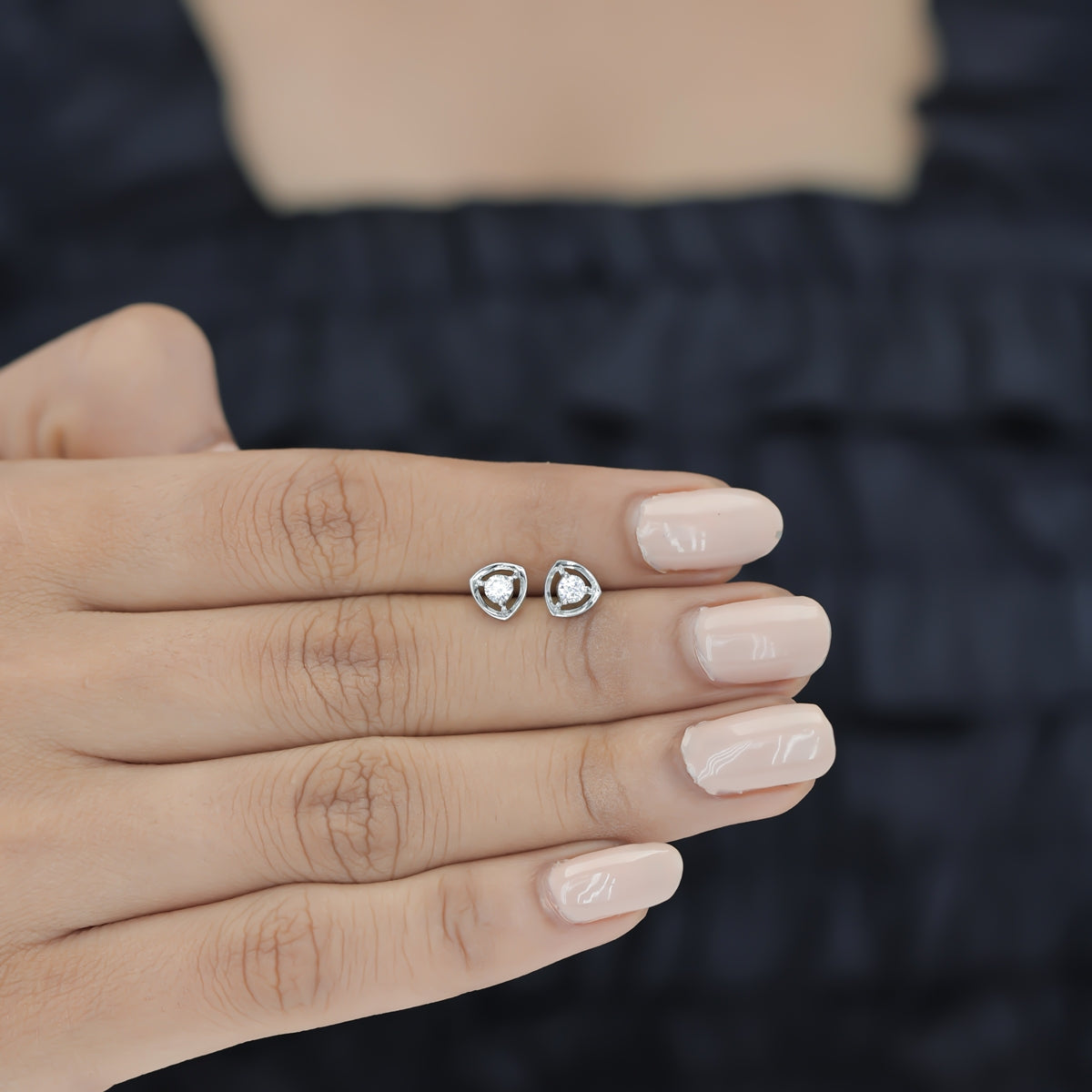 Triangle halo diamond stud earrings with open triangular frame and prong-set round centre stone